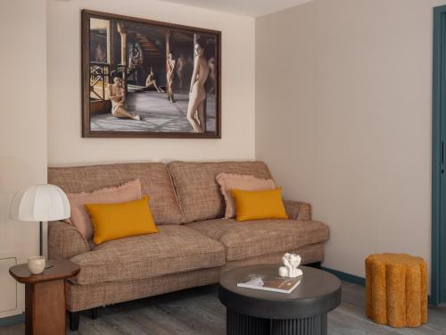 a living room with a brown couch and yellow pillows at Boudoir des Muses in Paris