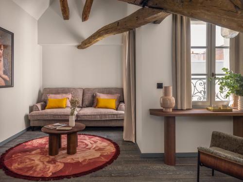 a living room with a couch and a table at Boudoir des Muses in Paris