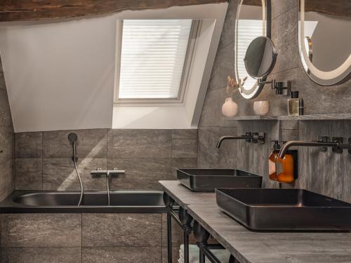 a bathroom with two sinks and two mirrors at Boudoir des Muses in Paris