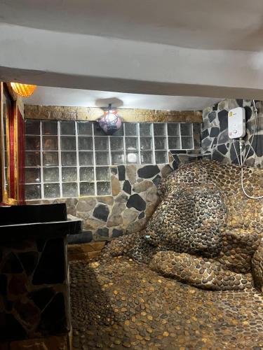 a room with a bed with a stone wall at Mai Pen Rai Bungalows in Than Sadet Beach