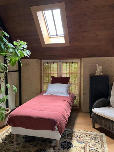 a bedroom with a bed and a skylight at Maison de vacances avec piscine chauffée, jacuzzi et jardin privé - proche circuit des 24h du Mans in Saint-Christophe-en-Champagne