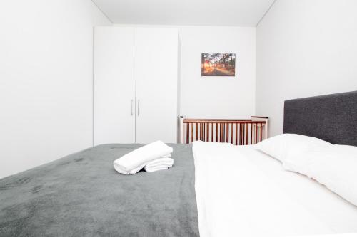 a bedroom with a bed with two towels on it at Sunny Pines Apartment in Palanga