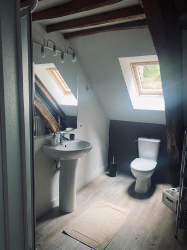 une salle de bain avec un lavabo et des toilettes et une fenêtre dans l'établissement Les Couleurs du Verger, à Beaumont-les-Autels