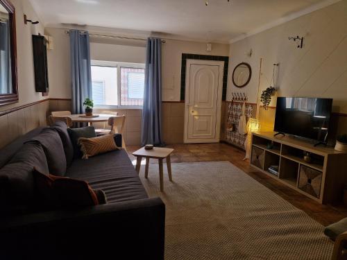 a living room with a couch and a tv at House with Private Roof Terrace in Centre in Tavira