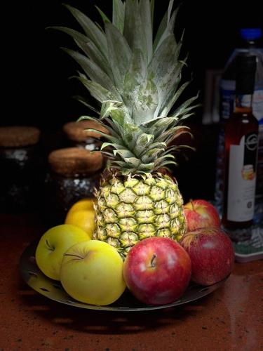a plate with a pineapple and fruit on a table at Azor International Hostel in Ponta Delgada