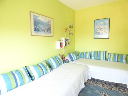 deux lits dans une chambre aux murs jaunes dans l'établissement Le Grand Foc, à Saint-Gilles-Croix-de-Vie