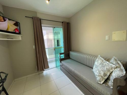 a room with a couch and a tv and a window at Residencial Alianza - Departamento de 1 habitación 204 in Bombinhas