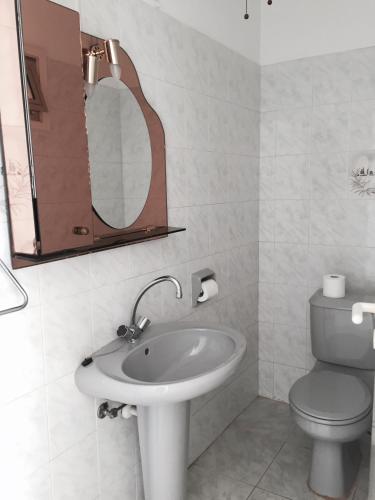 a bathroom with a sink and a toilet and a mirror at Erini Villa in Protaras