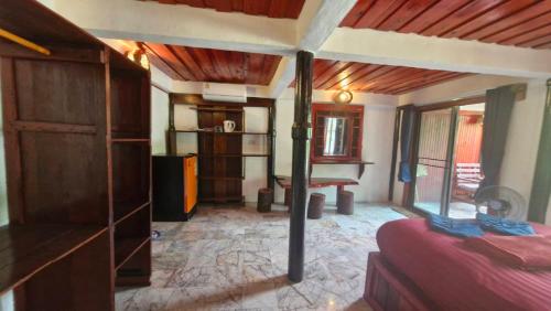 a room with a bedroom with a bed and a table at Mai Pen Rai Bungalows in Than Sadet Beach