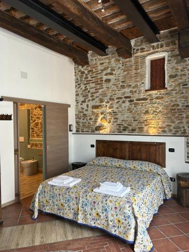 a bedroom with a bed and a stone wall at Ca'Silvia in San Savino