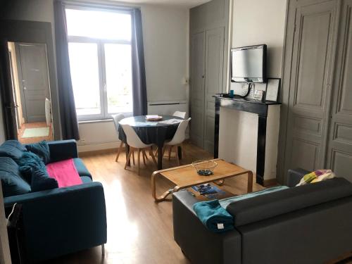 un salon avec deux canapés et une table dans l'établissement Appartement proche de la mer, à Dunkerque