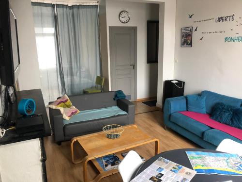 un salon avec un canapé bleu et une table dans l'établissement Appartement proche de la mer, à Dunkerque
