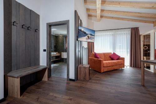 a living room with a couch and a mirror at Dolomiten Hotel Irma in Canazei