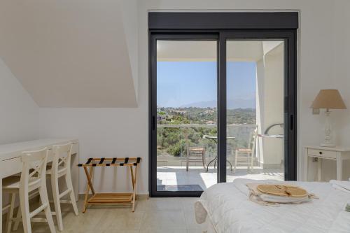 Un dormitorio con una cama y vista a un balcón. en THE BASE, en Almyrida