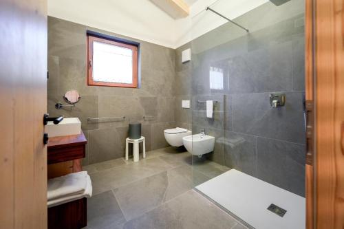 a bathroom with a shower and a toilet and a sink at Dolomiten Hotel Irma in Canazei