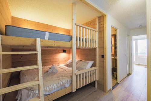 ein Schlafzimmer mit zwei Etagenbetten in einem Haus in der Unterkunft Le Berger - Apt dans résidence 4 étoiles au pied des pistes in Huez