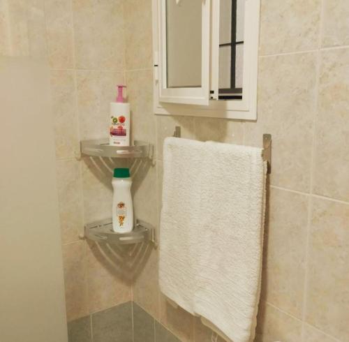 a bathroom with a towel and a mirror and a sink at APARTAMENTO SOL in Chipiona