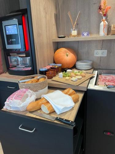a kitchen counter with bread and vegetables and a pumpkin at Chambres tourismes in Pepinster