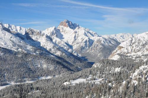 a mountain covered in snow and trees in the foreground at Albergo Chalet Lago Antorno in Misurina