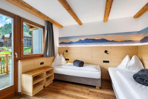 Een bed of bedden in een kamer bij Ciasa Funtanies Pütia