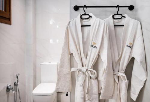 Villa Unique في نيدري: حمام به مناشف بيضاء على رف بجوار المرحاض