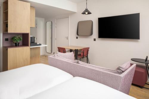 a living room with a couch and a table at Hyatt House Paris Charles de Gaulle Airport in Roissy-en-France
