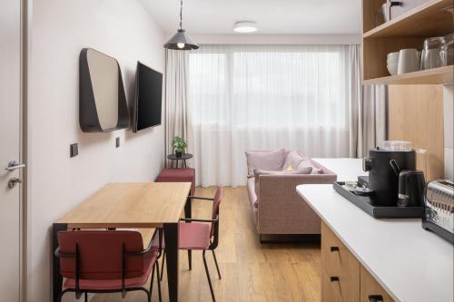 a kitchen and living room with a table and chairs at Hyatt House Paris Charles de Gaulle Airport in Roissy-en-France
