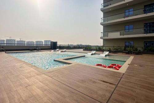 a swimming pool on the roof of a building at Waves - Stylish 1BR Close to IMG World & Global Village in Dubai