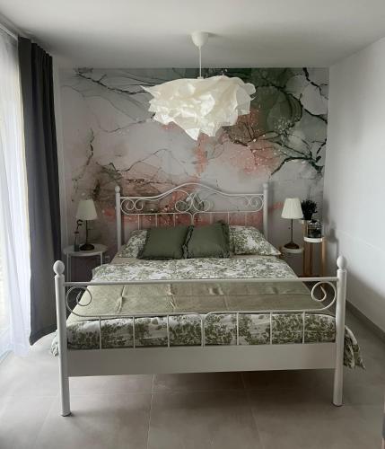 a bedroom with a bed with a painting on the wall at Robinsone House La Storia in Jelsa