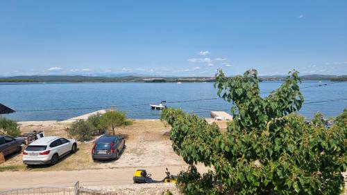 two cars parked next to a large body of water at Apartment Lana in Pašman