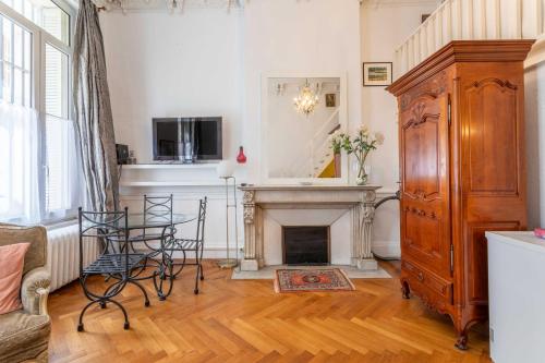 - un salon avec une cheminée, une table et des chaises dans l'établissement 1 bedroom duplex with AC near the Old Port, à Marseille