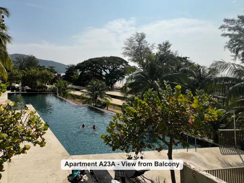 a resort swimming pool with people in the water at By the Sea- Pool and Sea View in Batu Ferringhi