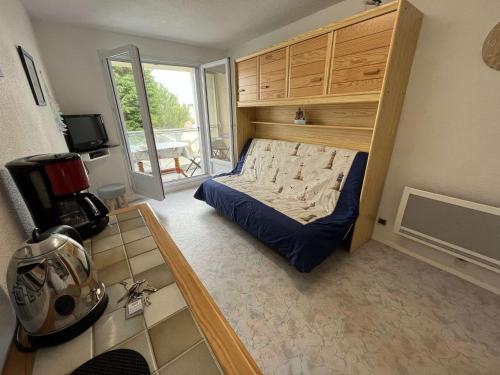 une petite chambre avec un lit et un balcon dans l'établissement Studio cosy proche mer avec balcon, garage et commerces à 1 km - Saint-Hilaire-de-Riez - FR-1-324-516, à Saint-Hilaire-de-Riez