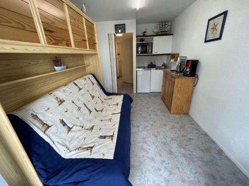 Cette petite chambre comprend un lit et une cuisine. dans l'établissement Studio cosy proche mer avec balcon, garage et commerces à 1 km - Saint-Hilaire-de-Riez - FR-1-324-516, à Saint-Hilaire-de-Riez