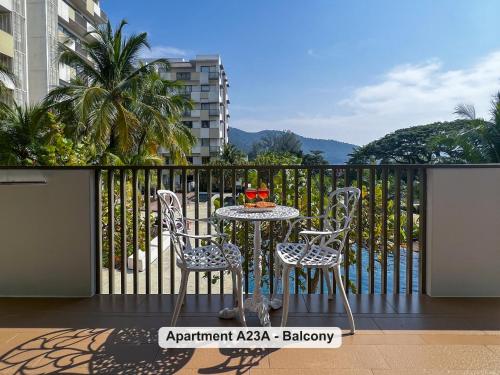 a table and two chairs on a balcony at By the Sea- Pool and Sea View in Batu Ferringhi
