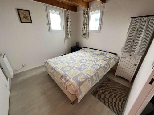 une petite chambre avec un lit et deux fenêtres dans l'établissement Appartement 2 pièces à St Hilaire-de-Riez avec parking et balcon - FR-1-324-145, à Saint-Hilaire-de-Riez