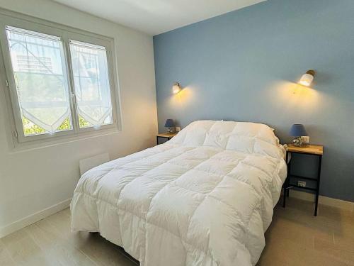 - une chambre avec un grand lit blanc et 2 tables de chevet dans l'établissement Appartement rénové face mer avec terrasse, 2 pièces, 3 couchages à La Baule - FR-1-245-193, à La Baule