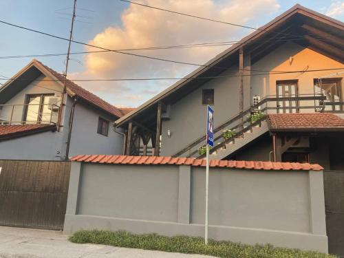 a house with a fence and a flag in front of it at Apartman Djokic 1 in Požarevac