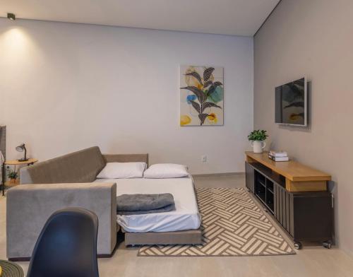 a room with a bed and a desk in it at Loft incrível em área nobre in Sinop