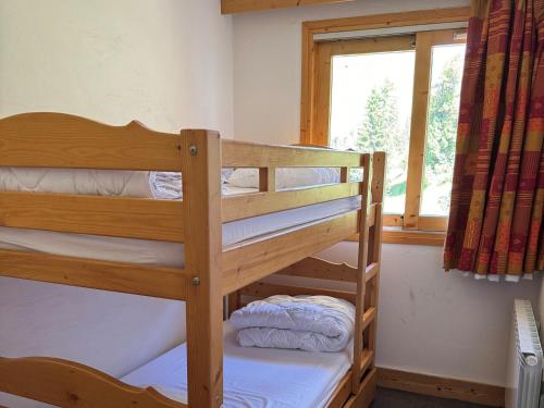 deux lits superposés dans une chambre avec fenêtre dans l'établissement Appartement cosy avec accès direct aux pistes, espace bien-être et piscine chauffée - FR-1-181-2813, à La Plagne Tarentaise