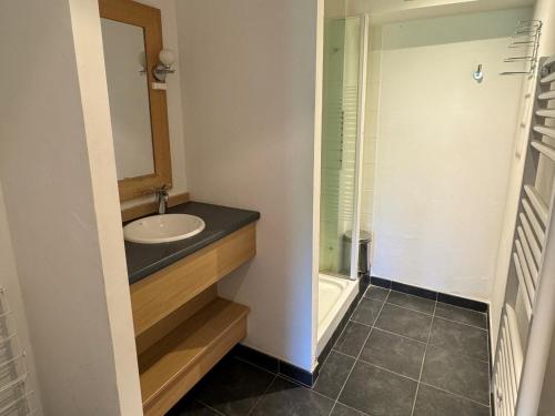 une salle de bain avec un lavabo et un miroir dans l'établissement Appartement cosy avec accès direct aux pistes, espace bien-être et piscine chauffée - FR-1-181-2813, à La Plagne Tarentaise