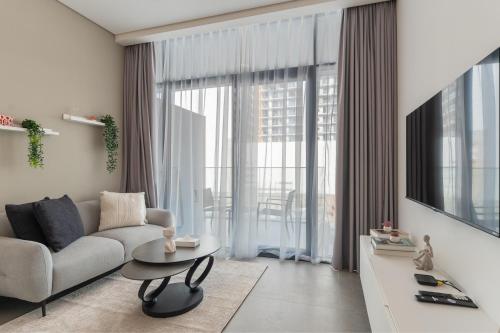 a living room with a couch and a table at HAVN - Smart Home Studio in Oxford Terraces, JVC in Dubai