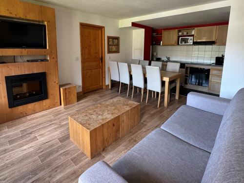 un salon avec un canapé et une table dans l'établissement Grand appartement ski aux pieds, orientation sud avec piscine, wifi et animaux admis - FR-1-181-2815, à La Plagne Tarentaise