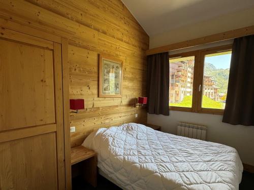 une chambre avec un lit dans une pièce en bois dans l'établissement Grand appartement ski aux pieds, orientation sud avec piscine, wifi et animaux admis - FR-1-181-2815, à La Plagne Tarentaise