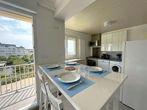 une cuisine avec une table et des chaises ainsi qu'une grande fenêtre dans l'établissement Appartement lumineux à 2 min de la plage avec balcon - FR-1-646-75, à Berck-sur-Mer