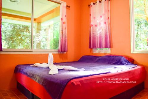 a bed in a room with a stuffed animal on it at Kama Siri Koh Kood in Ko Kood