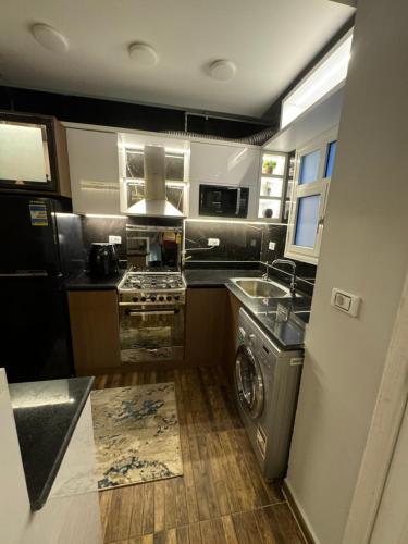 une cuisine avec une cuisinière et une machine à laver dans l'établissement Madinaty - 2 BedroomBeauty, à Madinaty