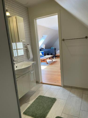 a bathroom with a sink and a door to a room at Strandsegård Ferielejlighed in Ølsted