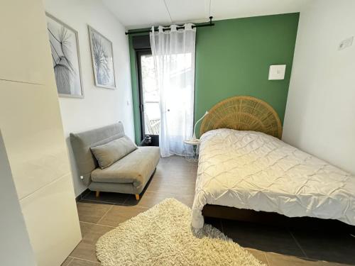 a bedroom with a bed and a chair and a window at Studio indépendant et cosy in Basse-Goulaine