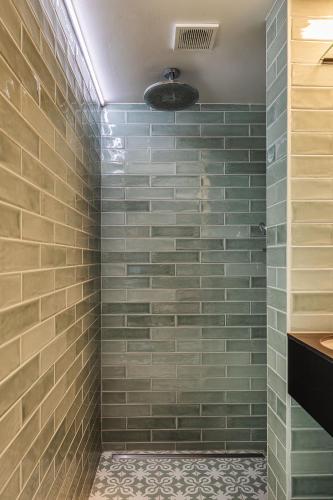 a bathroom with a shower with green tiles at In 't Wiel Oudenaarde in Oudenaarde